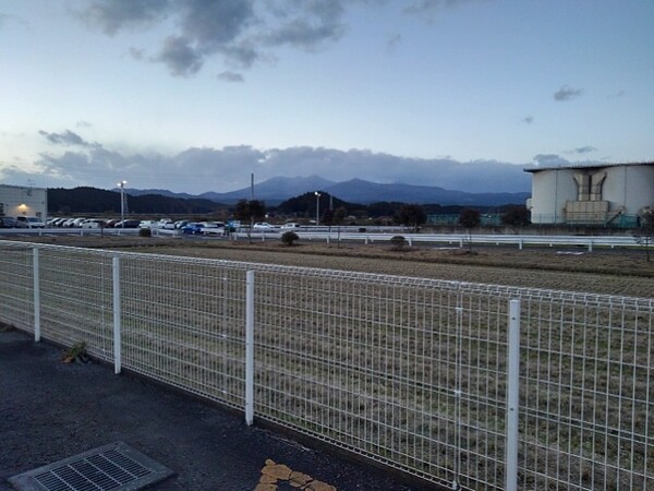 夕方のコンビニの駐車場から見えた山のある景色