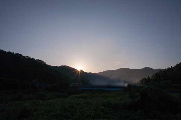 山の稜線からの朝日の出。