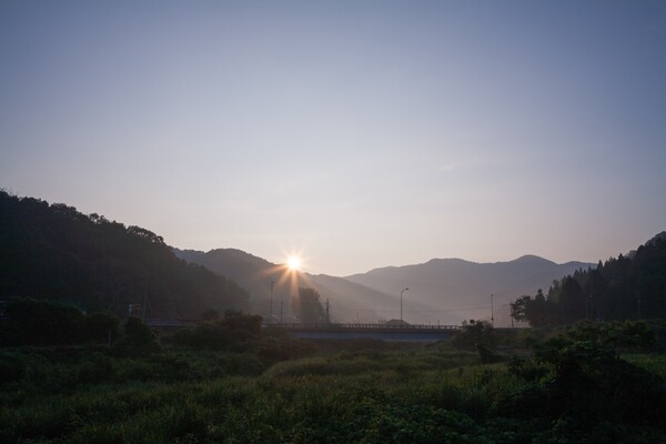 薄い雲に覆われた朝日の出。