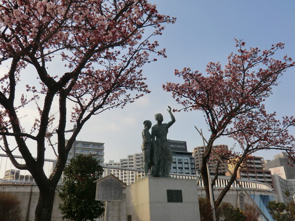 釜成屋平七像と満開のあたみ桜