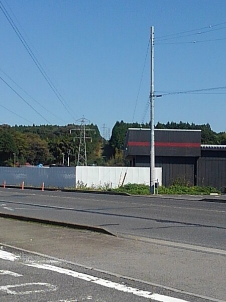 道路の向こうの案山子みたいな鉄塔