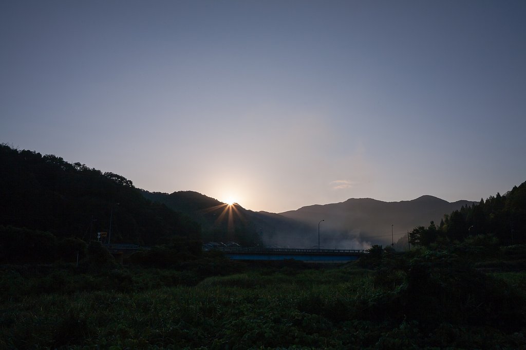 山の稜線からの朝日の出。