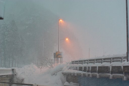 雪のバス停から国道を・・