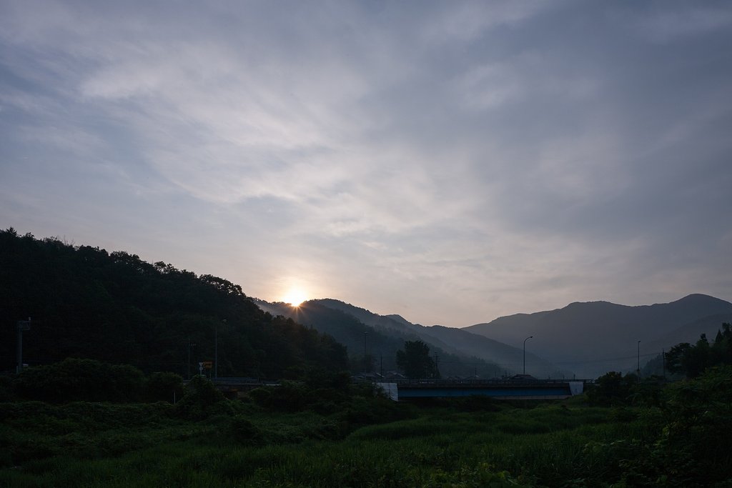 箒で掃いた様な雲の中の朝日の出。