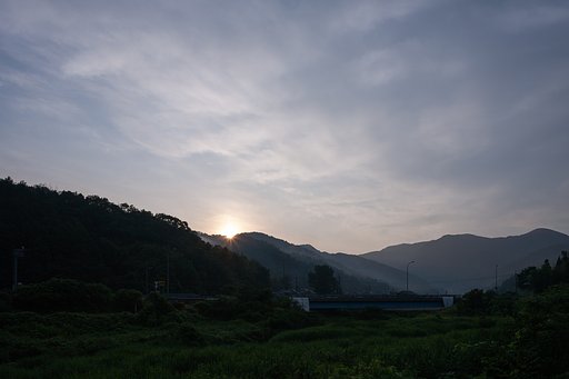 箒で掃いた様な雲の中の朝日の出。