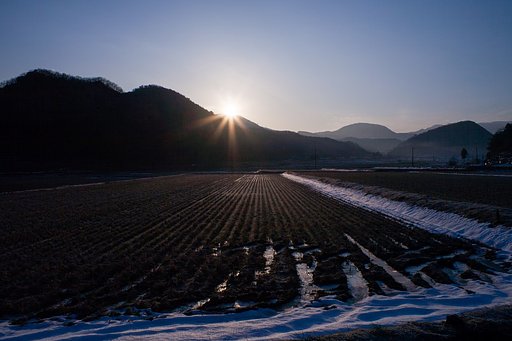 山の稜線からの朝日の出。