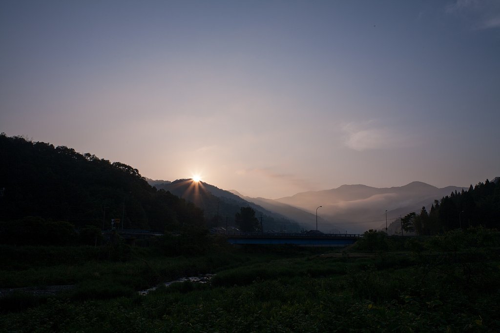 山の稜線からの朝日の出。
