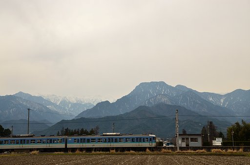 曇り空の有明山と無人駅