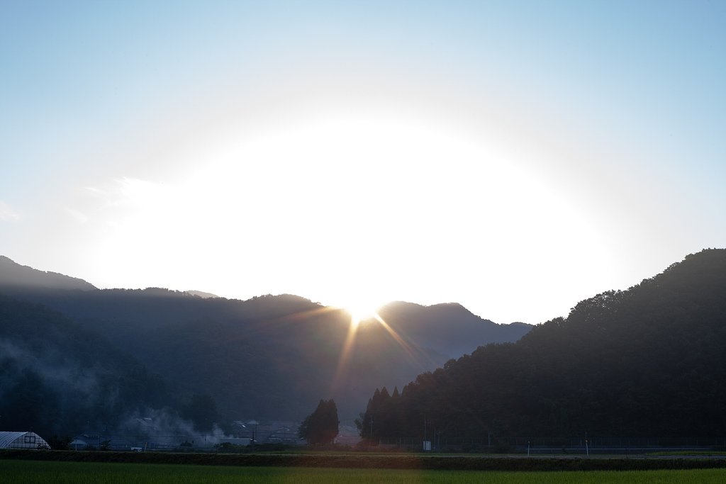 山の稜線からの朝日の出。