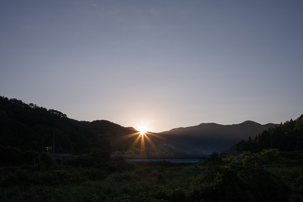 山の稜線からの朝日の出。