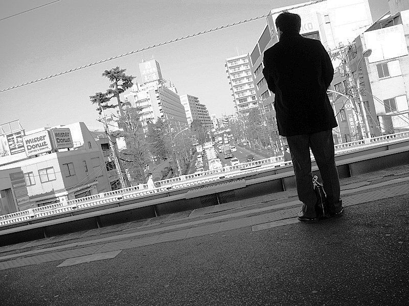 男の背中　ホームにて