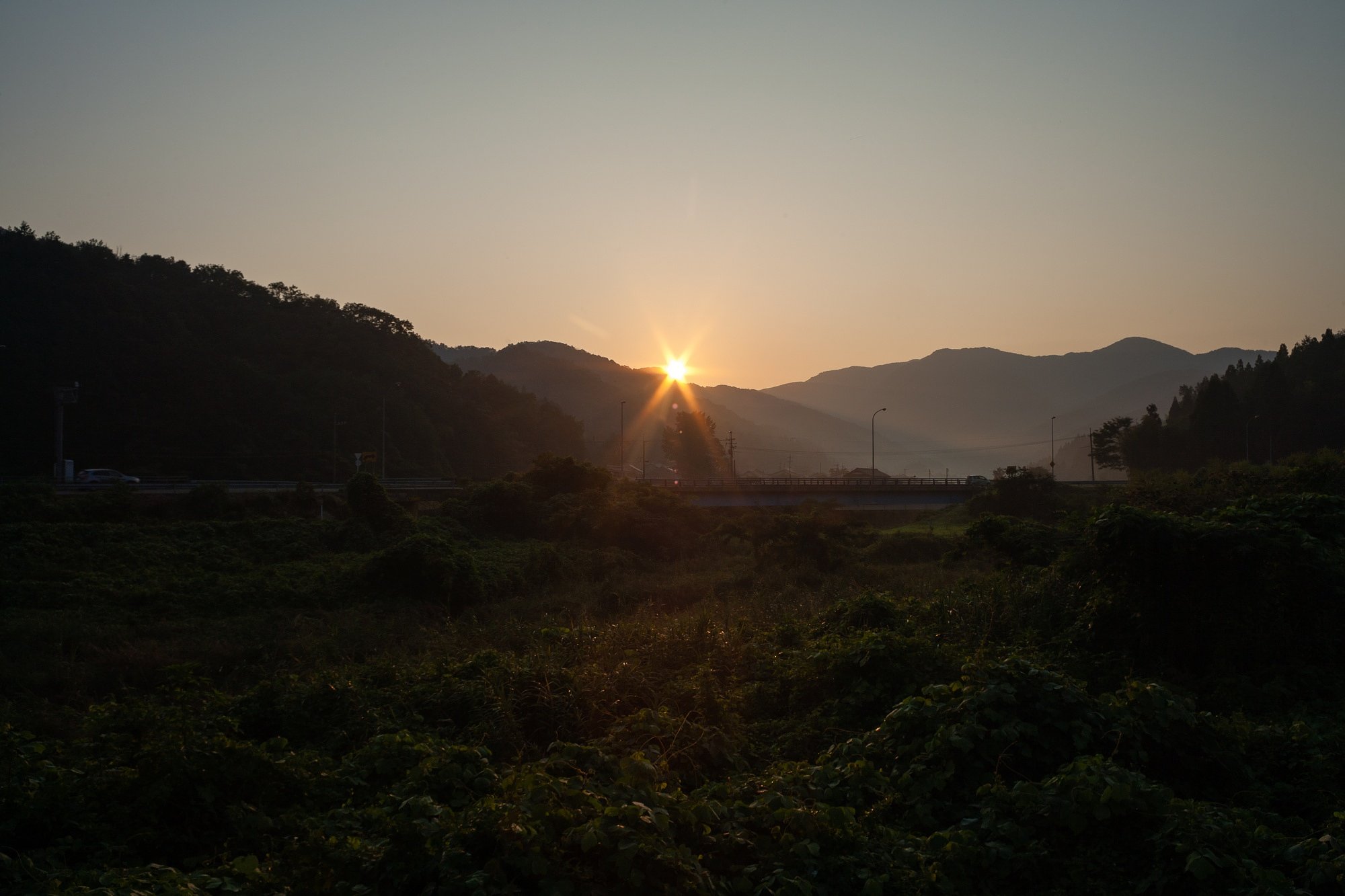 山の稜線からの朝日の出。