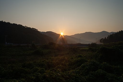 山の稜線からの朝日の出。