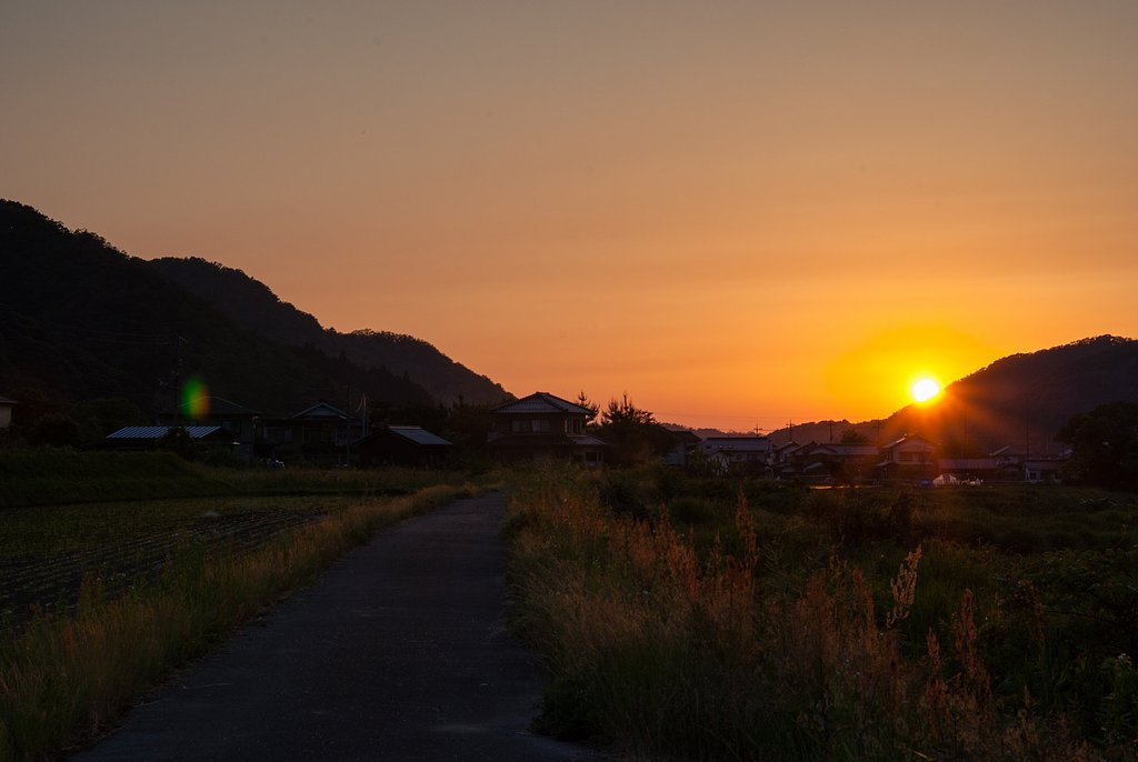 彩雲を伴い山の稜線へ日没!