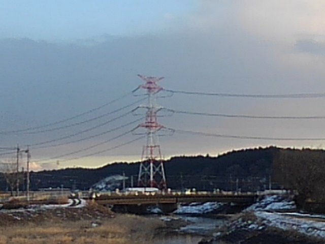 川の奥に見える赤と白の鉄塔