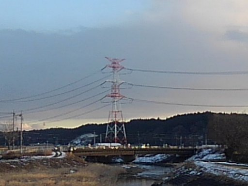 川の奥に見える赤と白の鉄塔