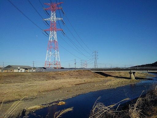 川の近くで見られた赤と白のツートンカラーの鉄塔