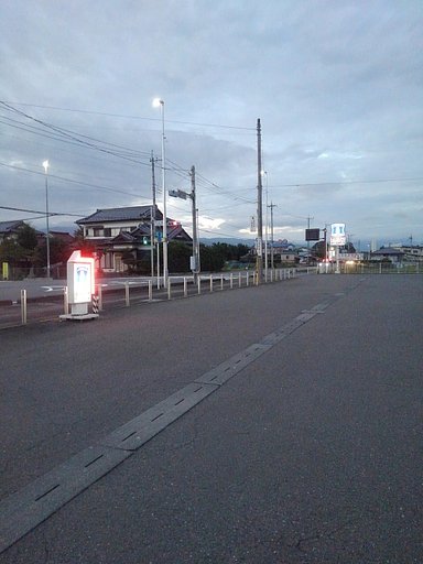 広々とした夕方のコンビニの駐車場