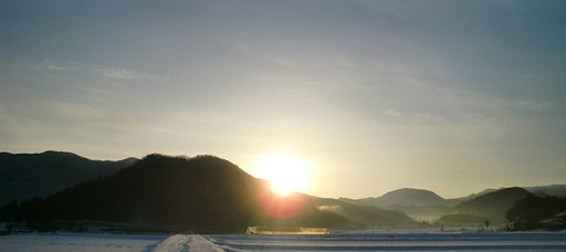 薄雲の朝日の出、顔を半分出した