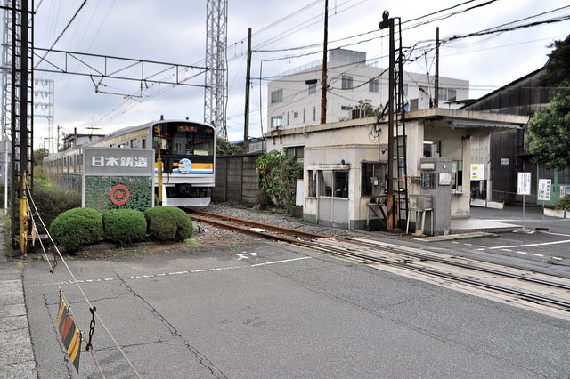 ハンドルを廻して遮断機を上げ下げする踏切